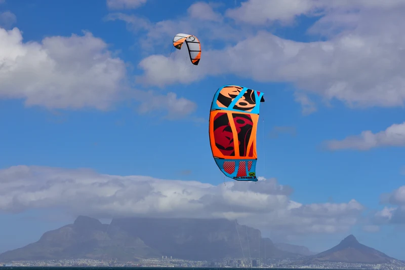 Kites above the sea at Bloubergstrand, with Table Mountain across the bay.